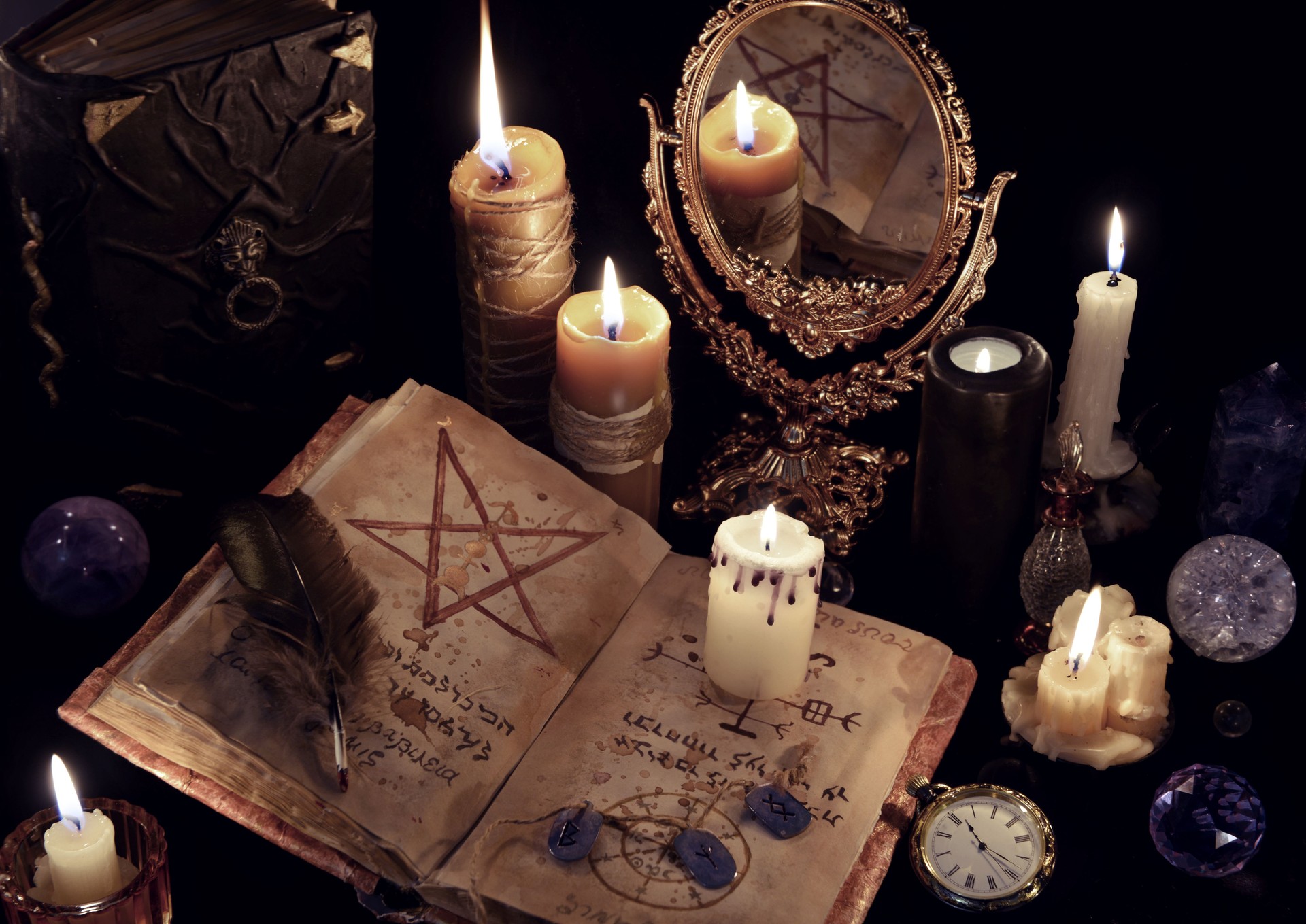 Magic still life with books, burning candles and mirrow