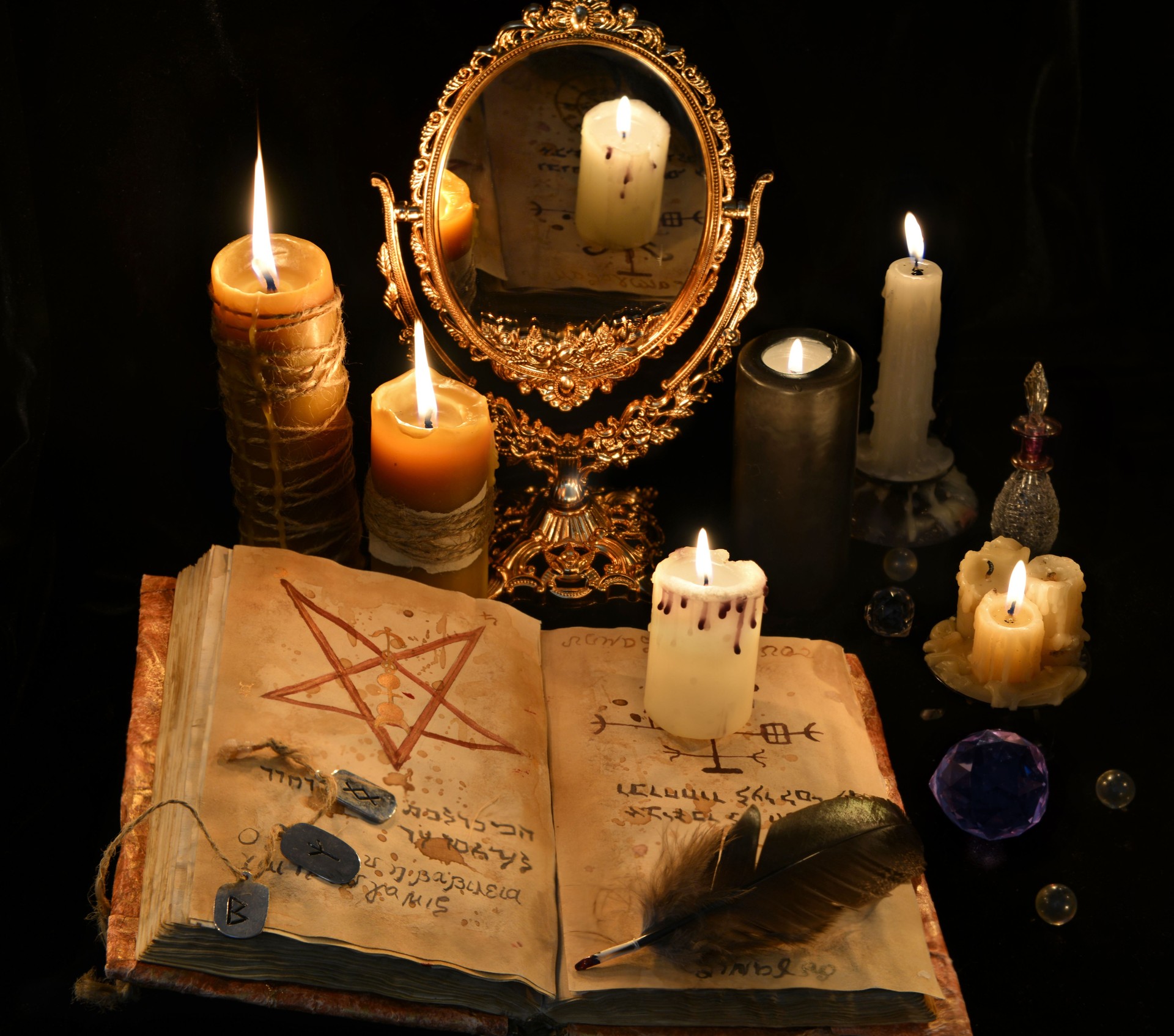 Mystic still life with black magic book, candles and mirrow