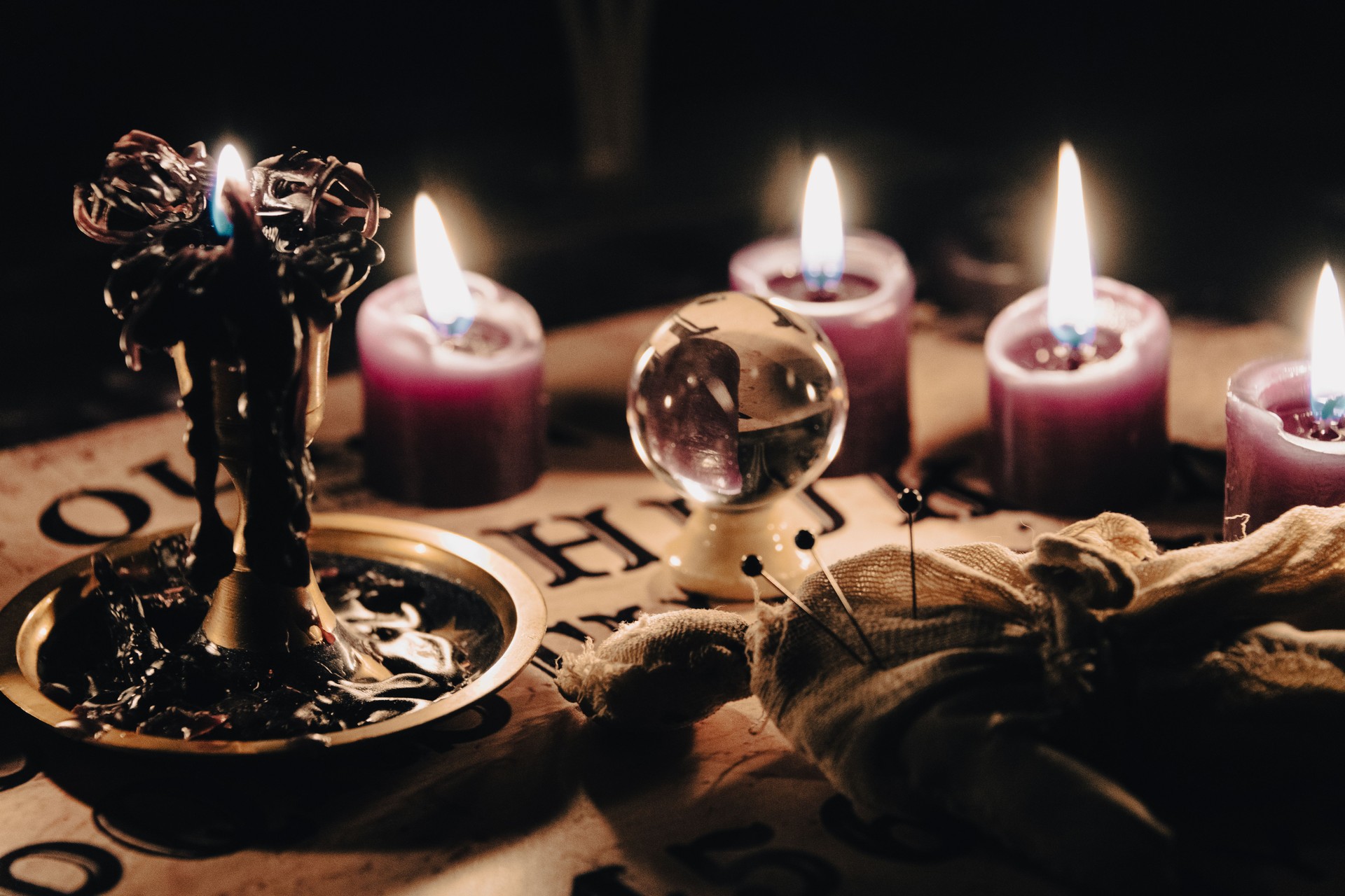 A mystical scene with a crystal ball surrounded by candles, suggesting fortune telling or a séance.