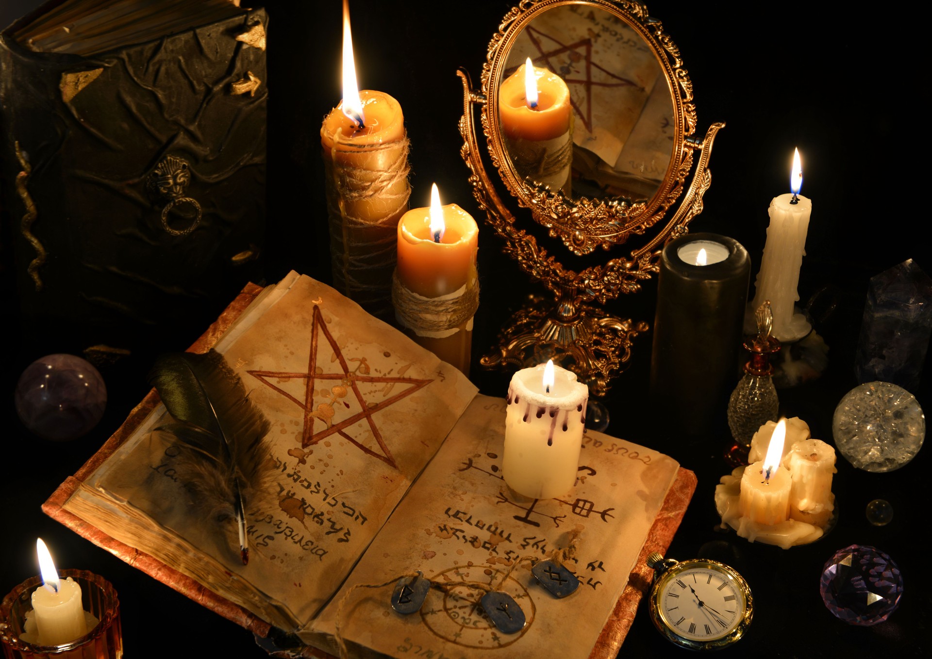 Magic still life with books, burning candles and mirrow